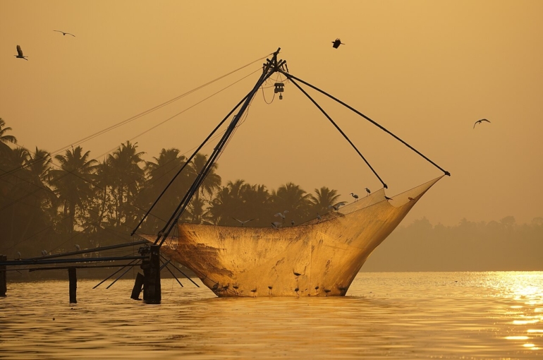 Chinese fishing net being raised at sunrise.  Ashtamudi Lake, Kollam, Kerala, India