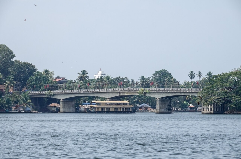 Houseboat passing under Thevally Bridge, Ashtamudi Lake, Kollam, Kerala, India