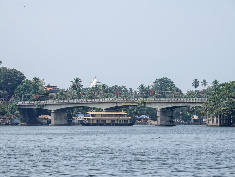 Houseboat passing under Thevally Bridge, Ashtamudi Lake, Kollam, Kerala, India