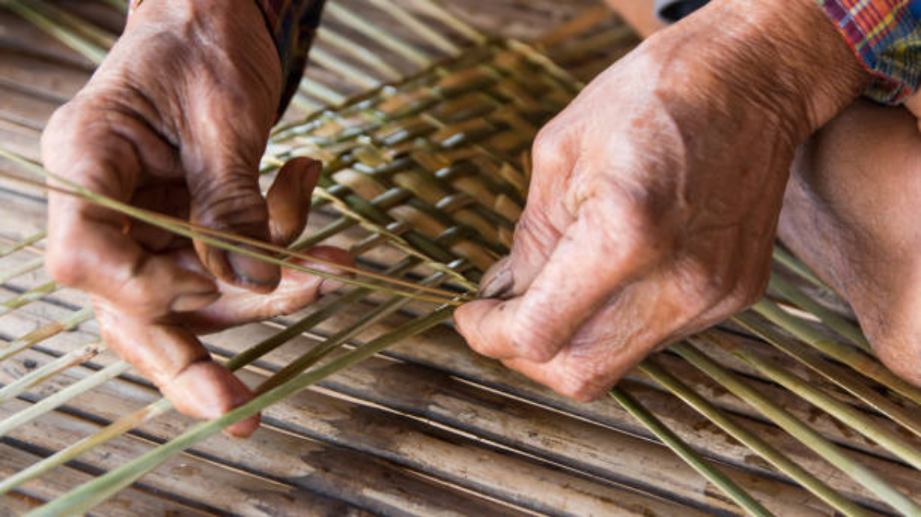 Old man hands manually weaving bamboo.